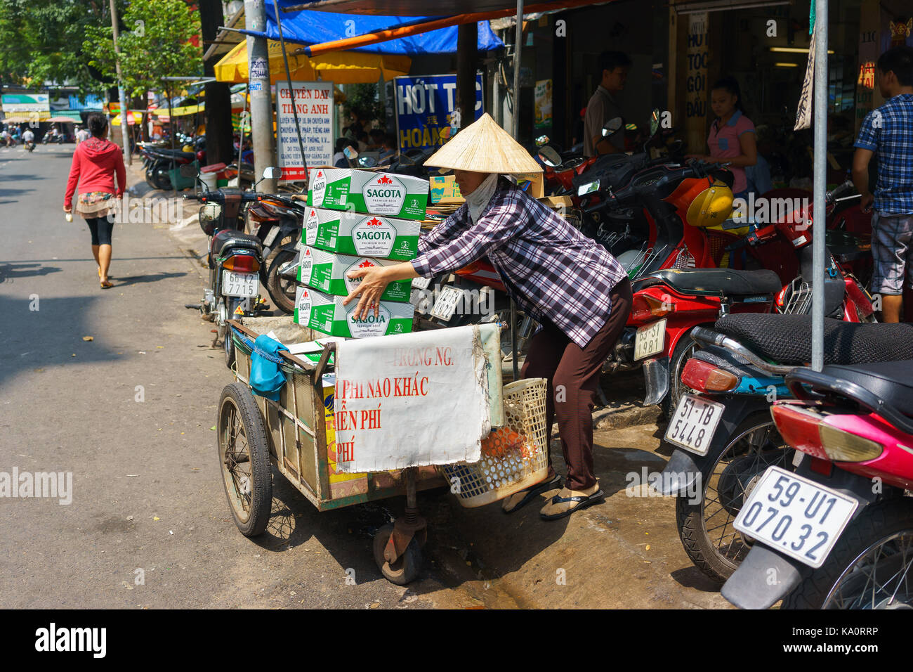 SAIGON, VIETNAM - October 16, 2014: A garbage collector collecting carton boxes on a small street, Saigon, Vietnam Stock Photo