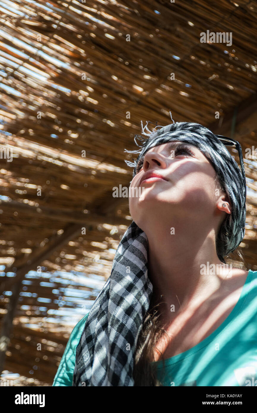 Girl hiding from the sun in the shade of The Bedouin house. Stock Photo