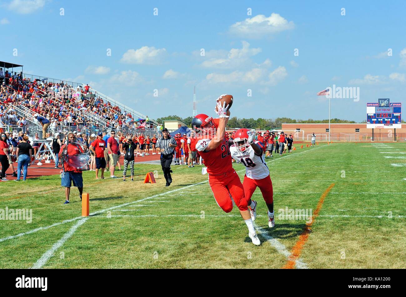 Receiver gathering in a touchdown pass from his quarterback after beating an opposing defensive