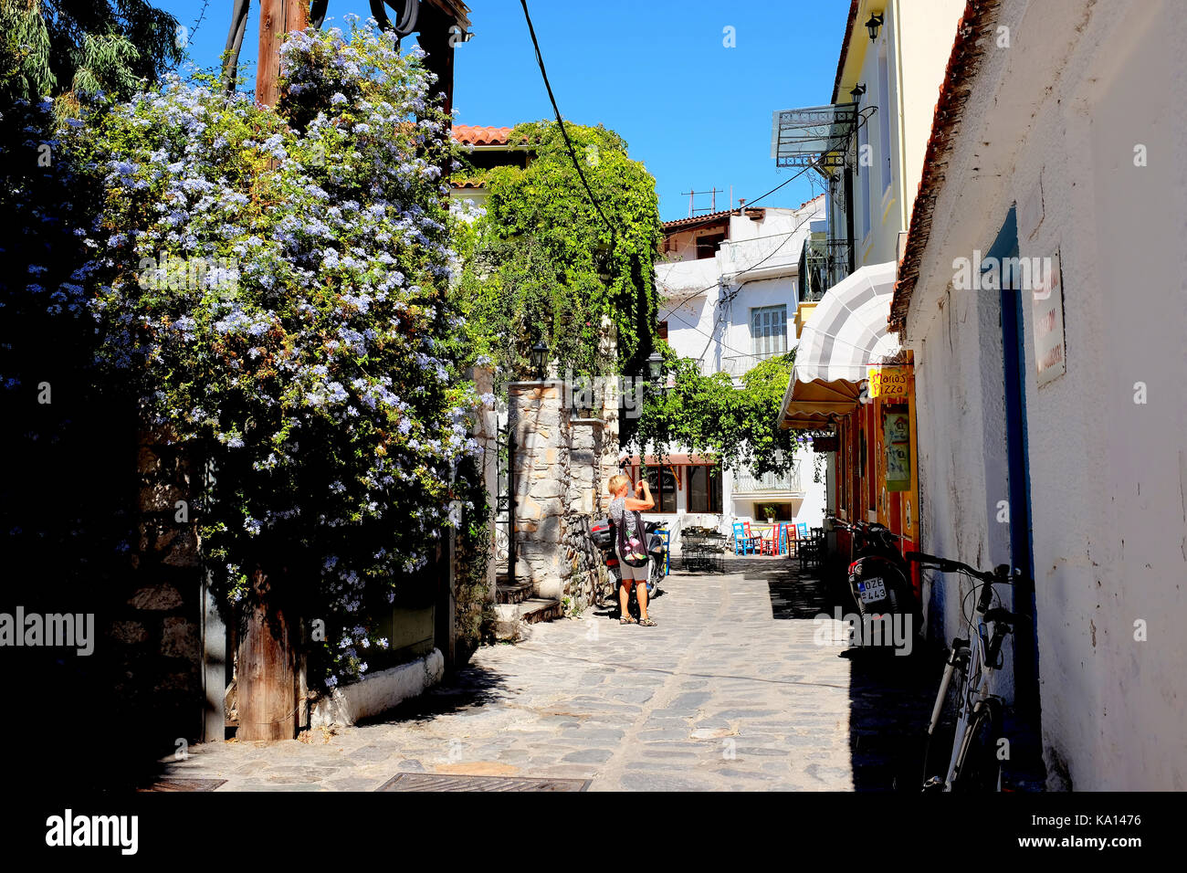 Skiathos, Greece. September 13, 2017.  A colorful street in Skiathos town where nature takes over with flowers and climbing plants in the back streets Stock Photo