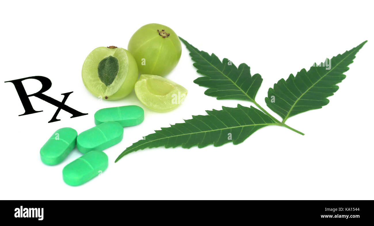 Amla fruits  and green tablets prescribed as alternative medicine Stock Photo