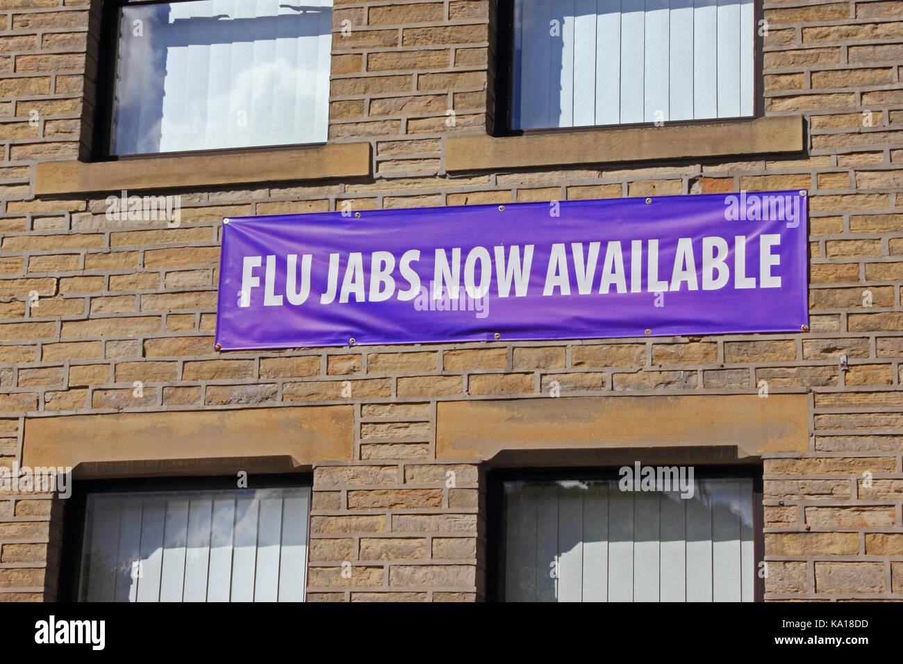 Flu Jabs Now Available, sign on wall of Doctor's surgery Stock Photo