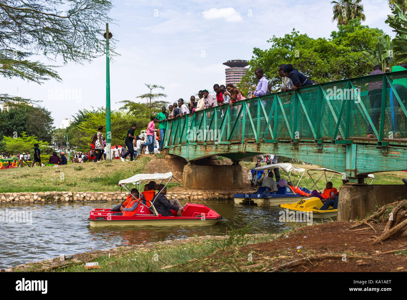 People enjoying peddle boat rides as they go under a small bridge with ...