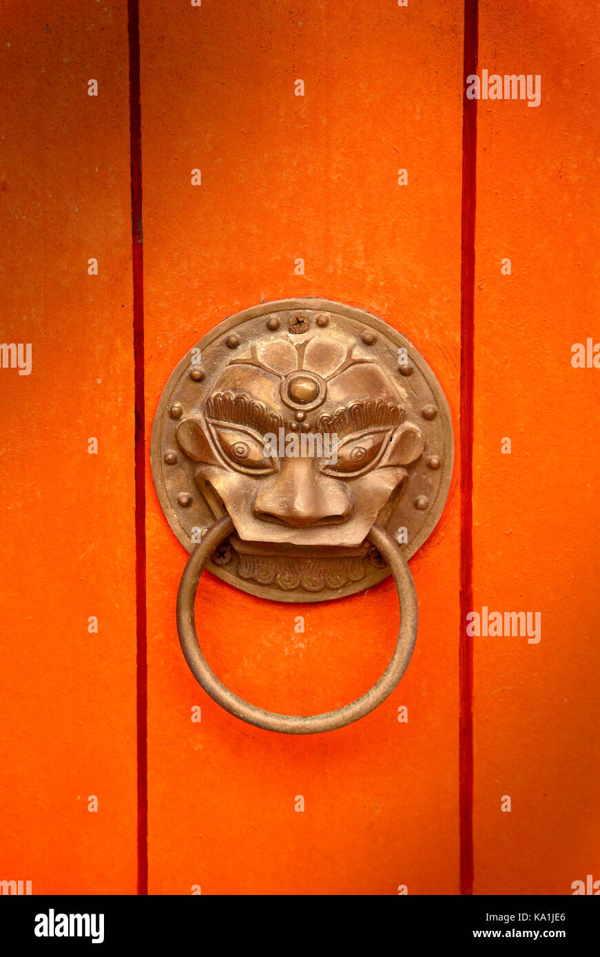 Oriental brass door handle, gold finish orange door Stock Photo