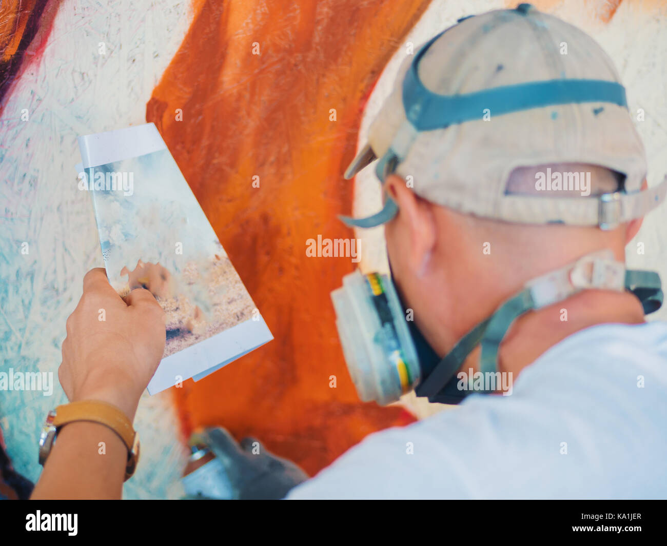 Graffiti Artist Painting On The Street Wall. Man with aerosol spray ...