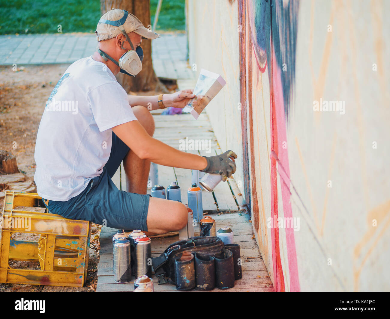 Graffiti Artist Painting On The Street Wall. Man with aerosol spray ...