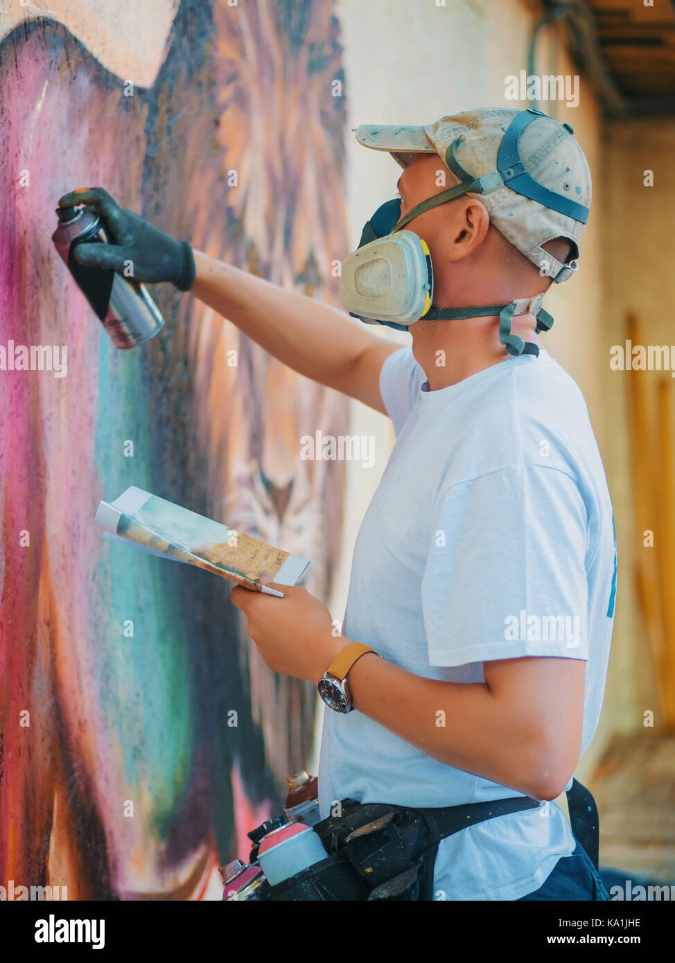 Graffiti Artist Painting On The Street Wall. Man with aerosol spray ...