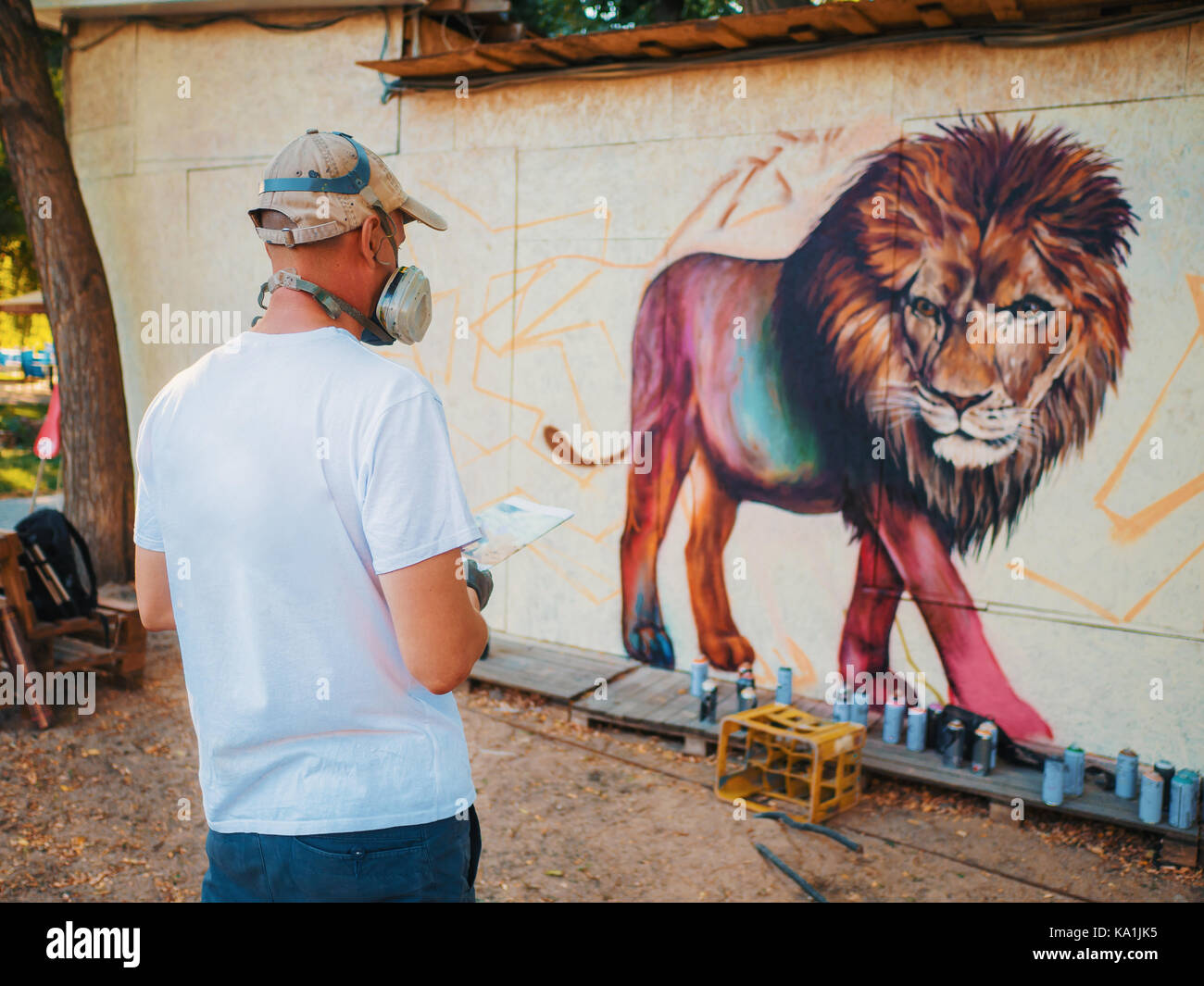 Graffiti Artist Painting On The Street Wall. Man with aerosol spray ...