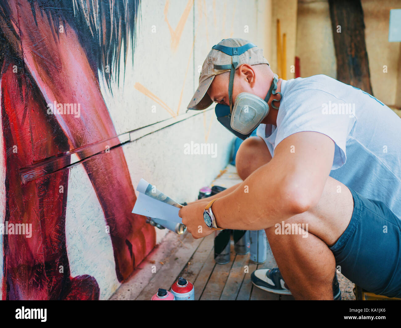 Graffiti Artist Painting On The Street Wall. Man with aerosol spray ...