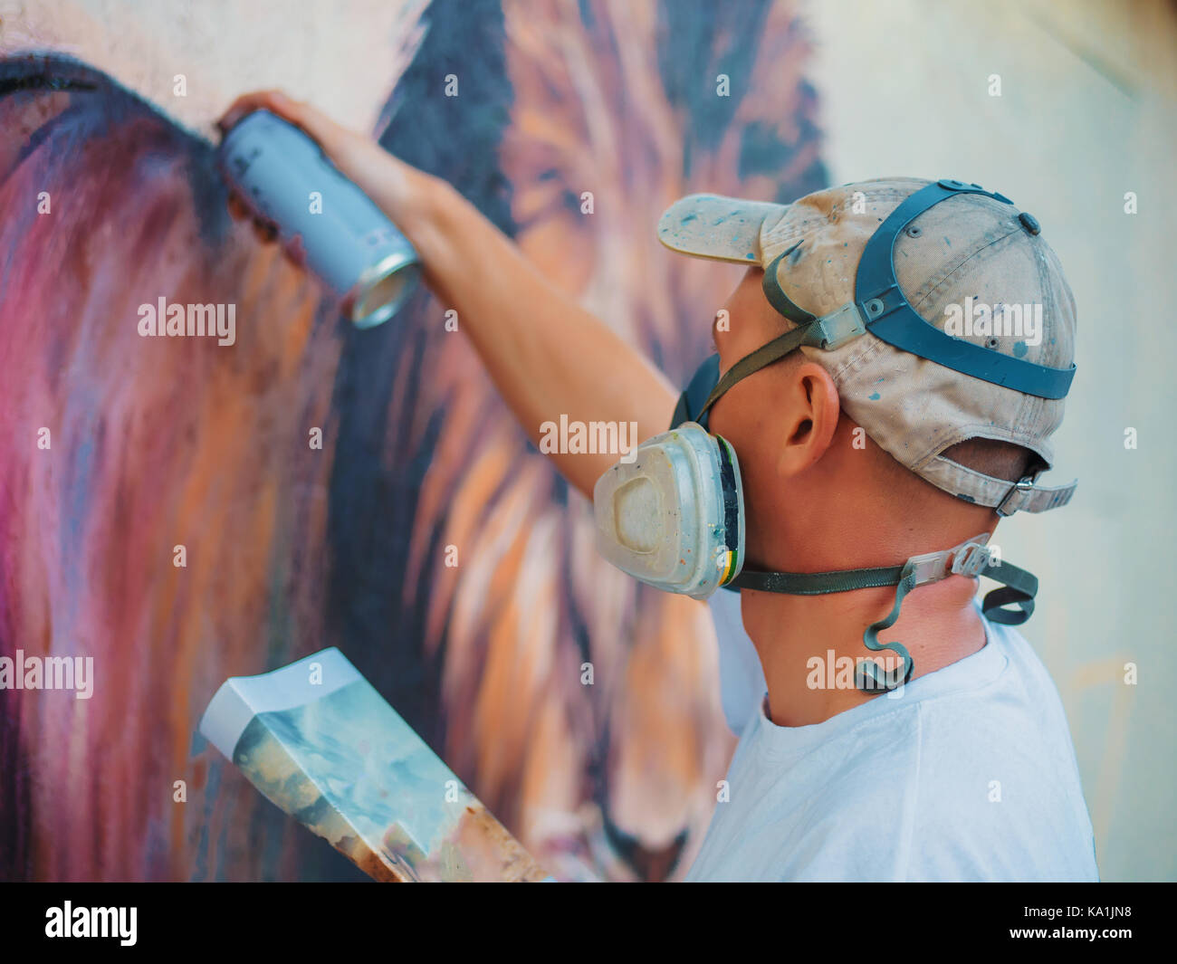 Graffiti Artist Painting On The Street Wall. Man with aerosol spray ...