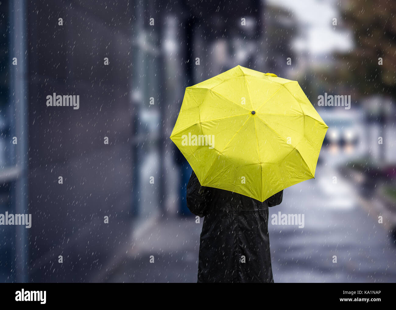 Woman walking on rainy day with yellow umbrella Stock Photo - Alamy