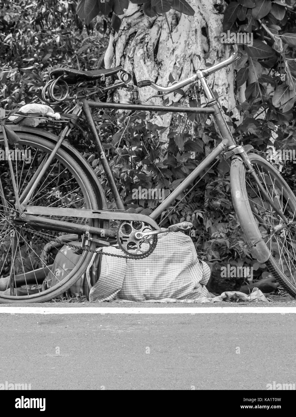 A homeless man sleeping by the road side. Stock Photo