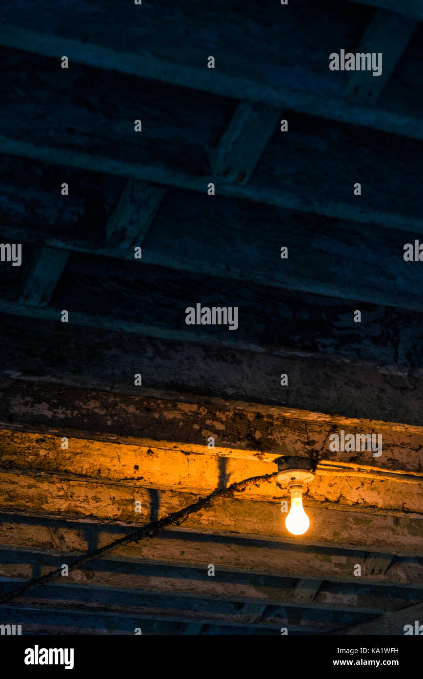 Light bulb inside derelict old building on Alcatraz Island, San