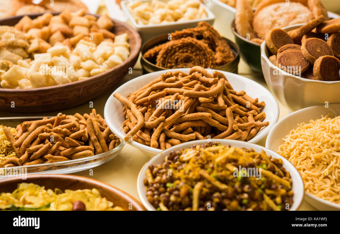 stock photo of  Diwali food or Diwali snacks or Diwali sweets like anarsa, bakarvadi, chakli, sev, bhujiya, shankar pale and chivda or chiwada, karanj Stock Photo