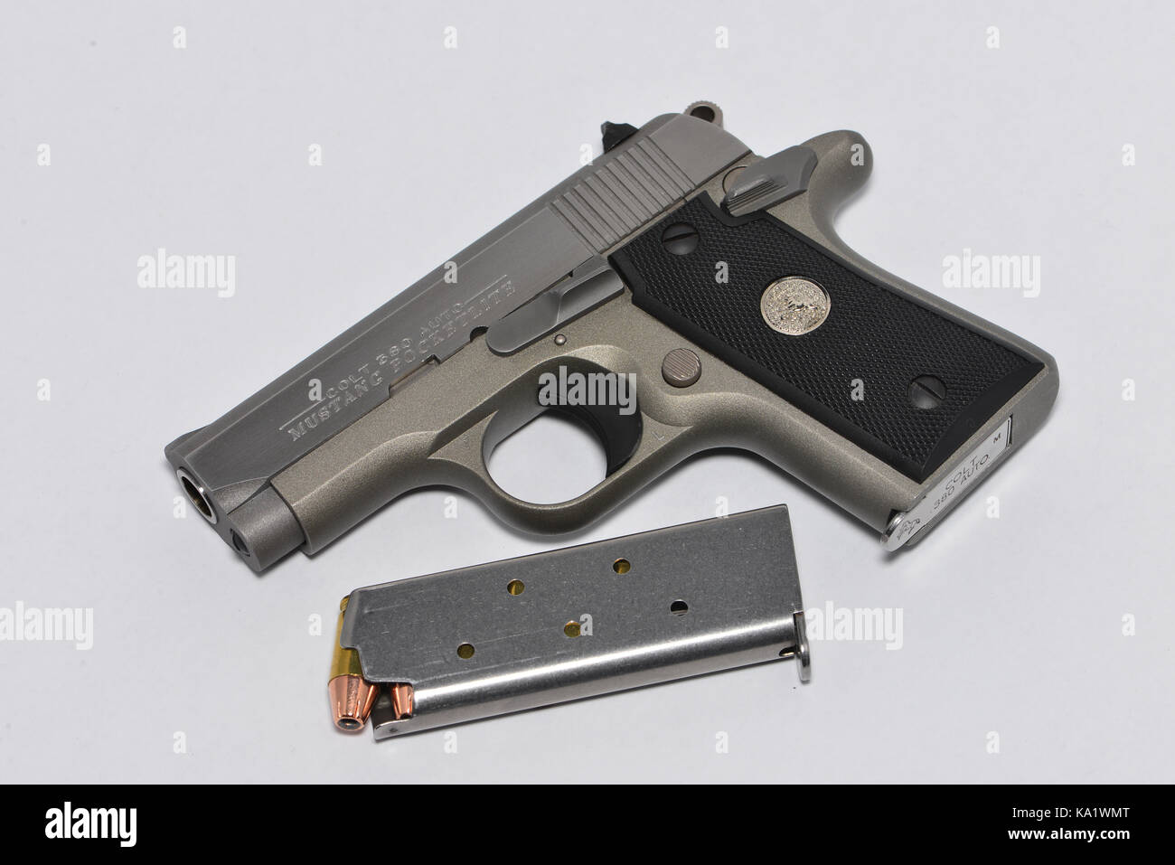 A loaded Colt Mustang .380 pocket pistol with an extra magazine full of jacketed hollow point bullets. Stock Photo