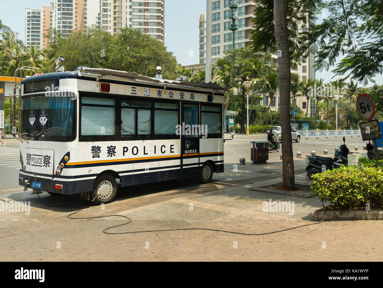 Police bus is charging from the power grid in the tourist city of Sanya Stock Photo