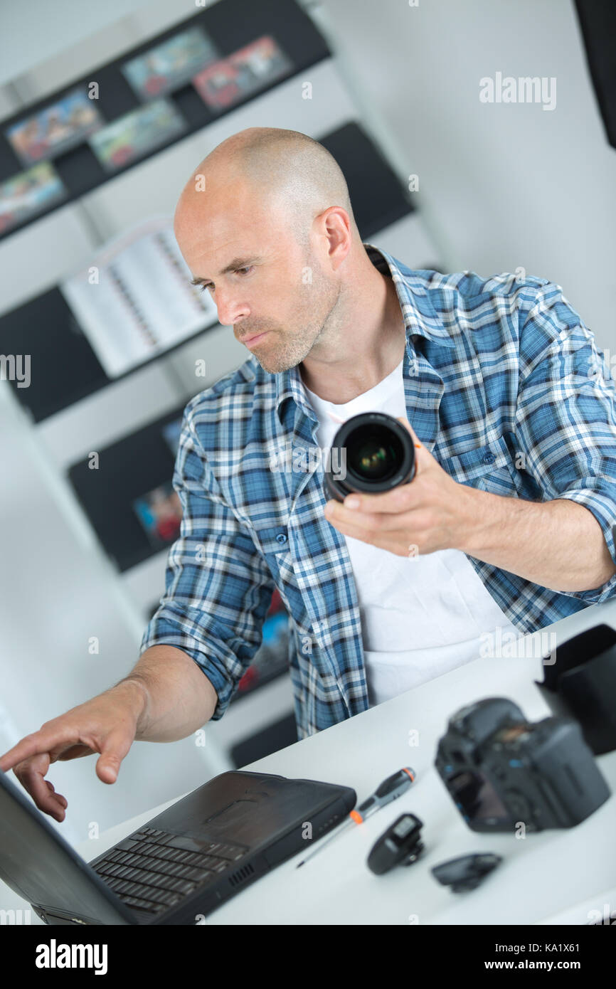 photographer checking his digital pictures on laptop in agency Stock ...