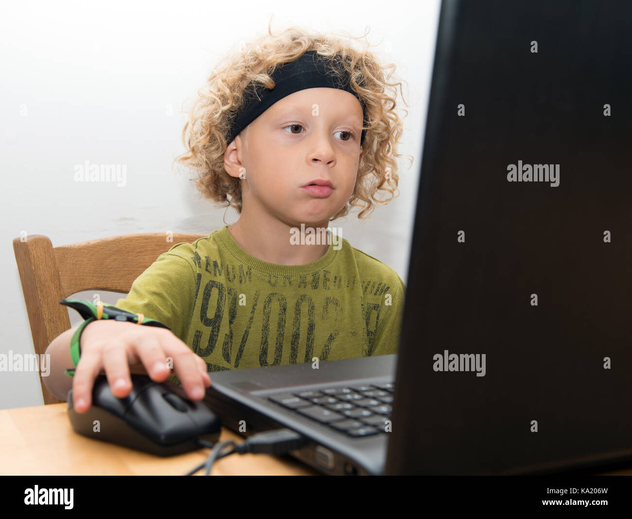 a portrait of a little blond boy using a laptop Stock Photo - Alamy