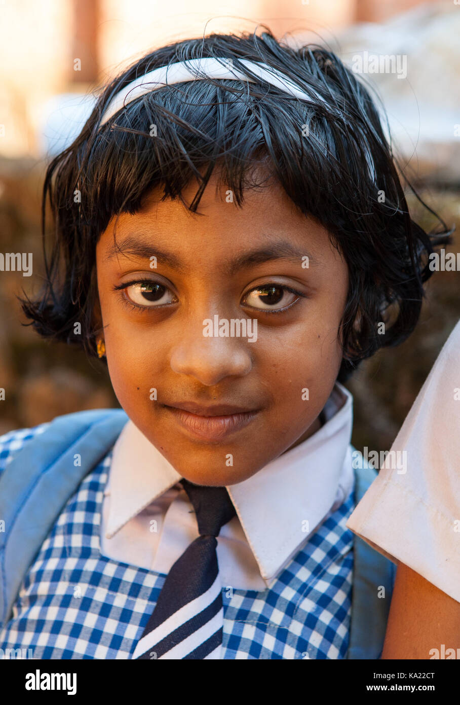 Rural residents in daily life.  Little girl in school uniform. The girl had a traditional  children eye makeup and lips. Stock Photo