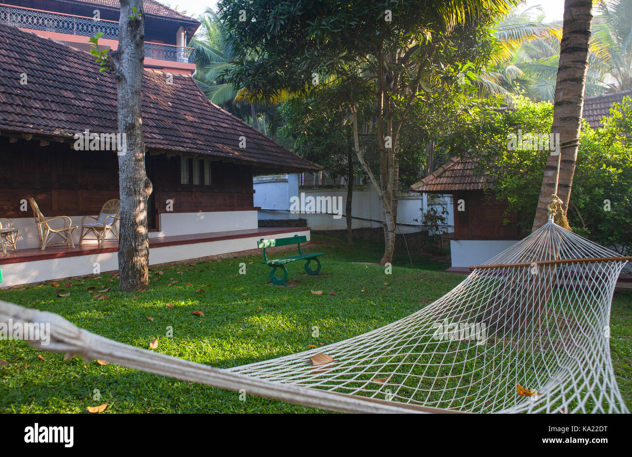 Ayurvedic clinic. Hammock hanging on a palm tree near the cottages in the Kerala style. Stock Photo