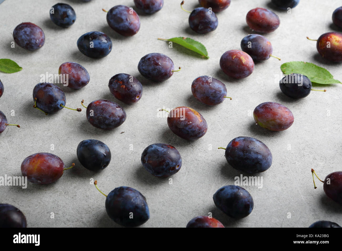 Plums range on concrete, food closeup Stock Photo Alamy