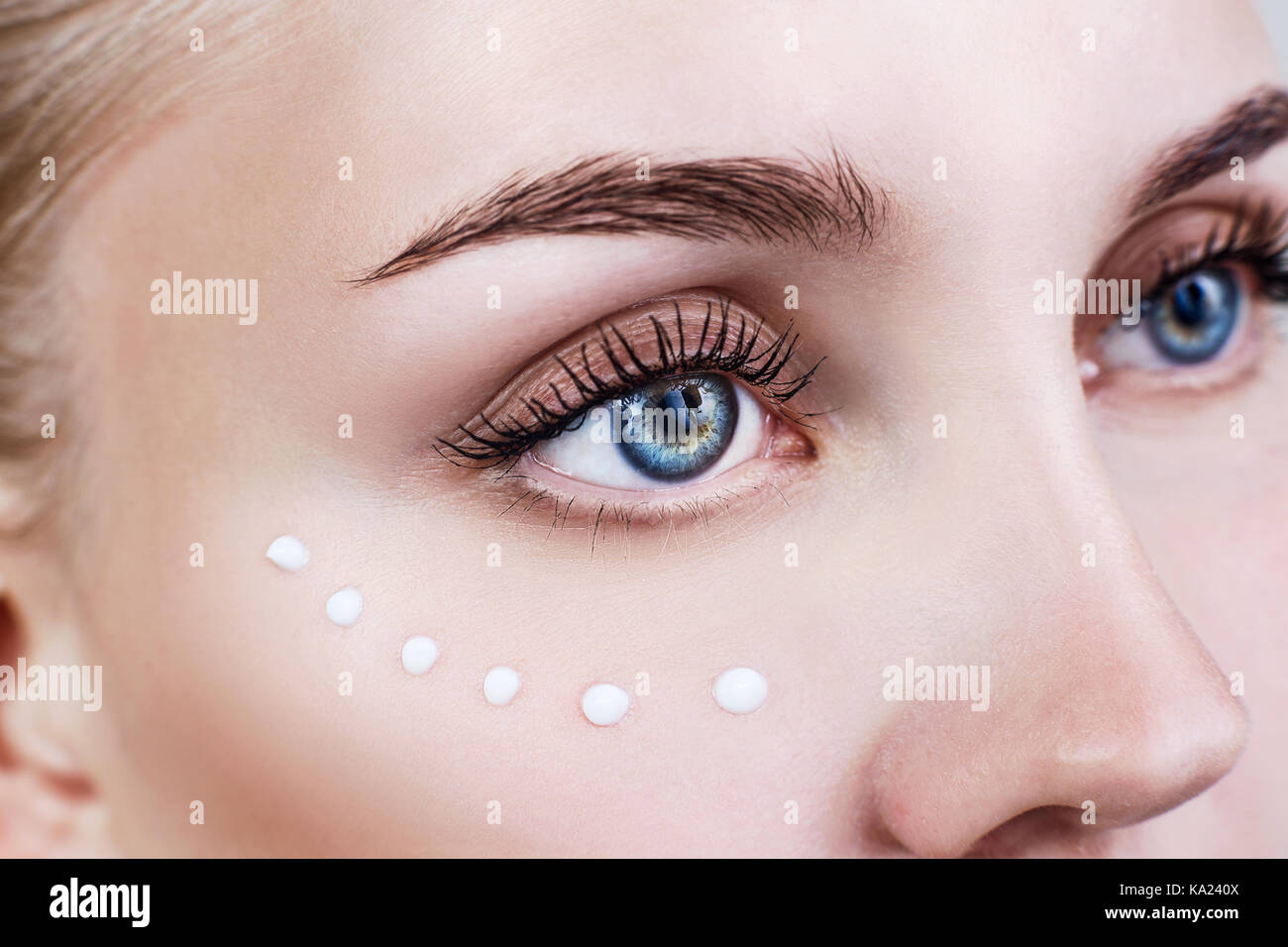 Young woman with cream on clean fresh face. Stock Photo
