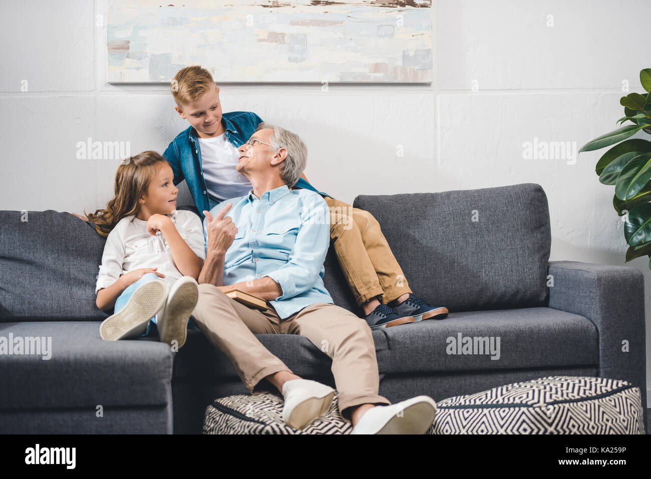grandfather and grandchildren sitting on sofa  Stock Photo