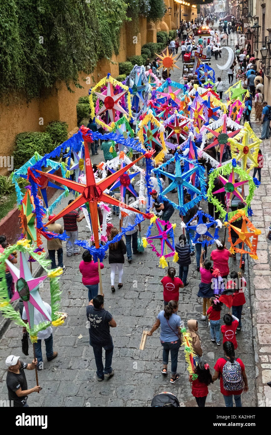 Colorful paper stars march in a fiesta procession through the city at the start of the week long fiesta of the patron saint Saint Michael September 22, 2017 in San Miguel de Allende, Mexico. Stock Photo