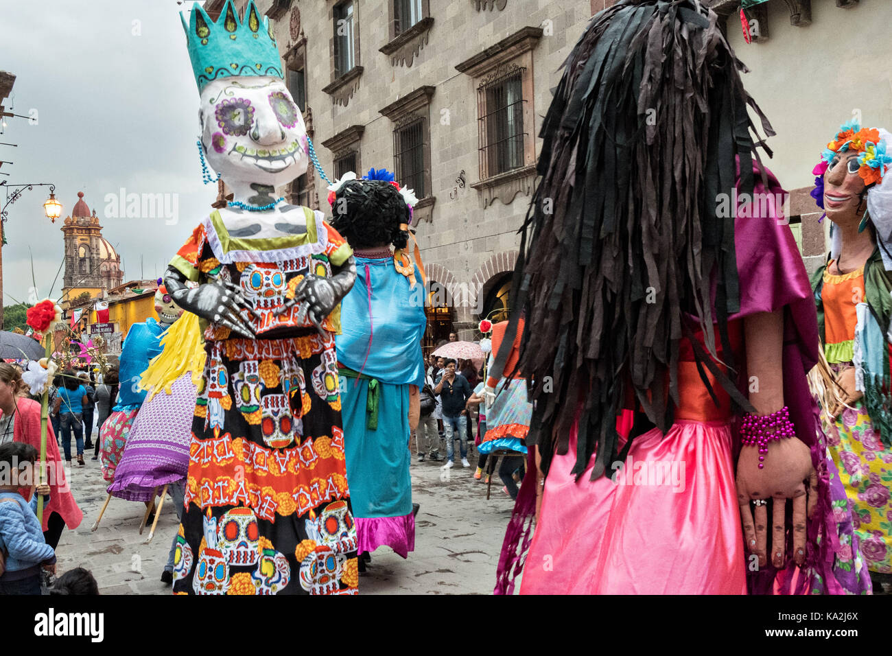 A parade of giant paper-mache puppets called mojigangas dance in a procession through the city at the start of the week long fiesta of the patron saint Saint Michael September 22, 2017 in San Miguel de Allende, Mexico. Stock Photo