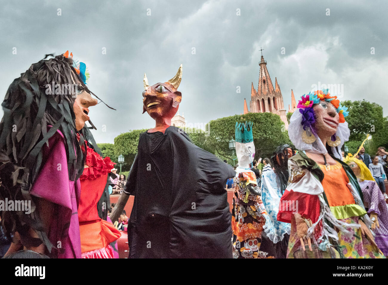 A parade of giant paper-mache puppets called mojigangas dance in a procession through the city at the start of the week long fiesta of the patron saint Saint Michael September 22, 2017 in San Miguel de Allende, Mexico. Stock Photo