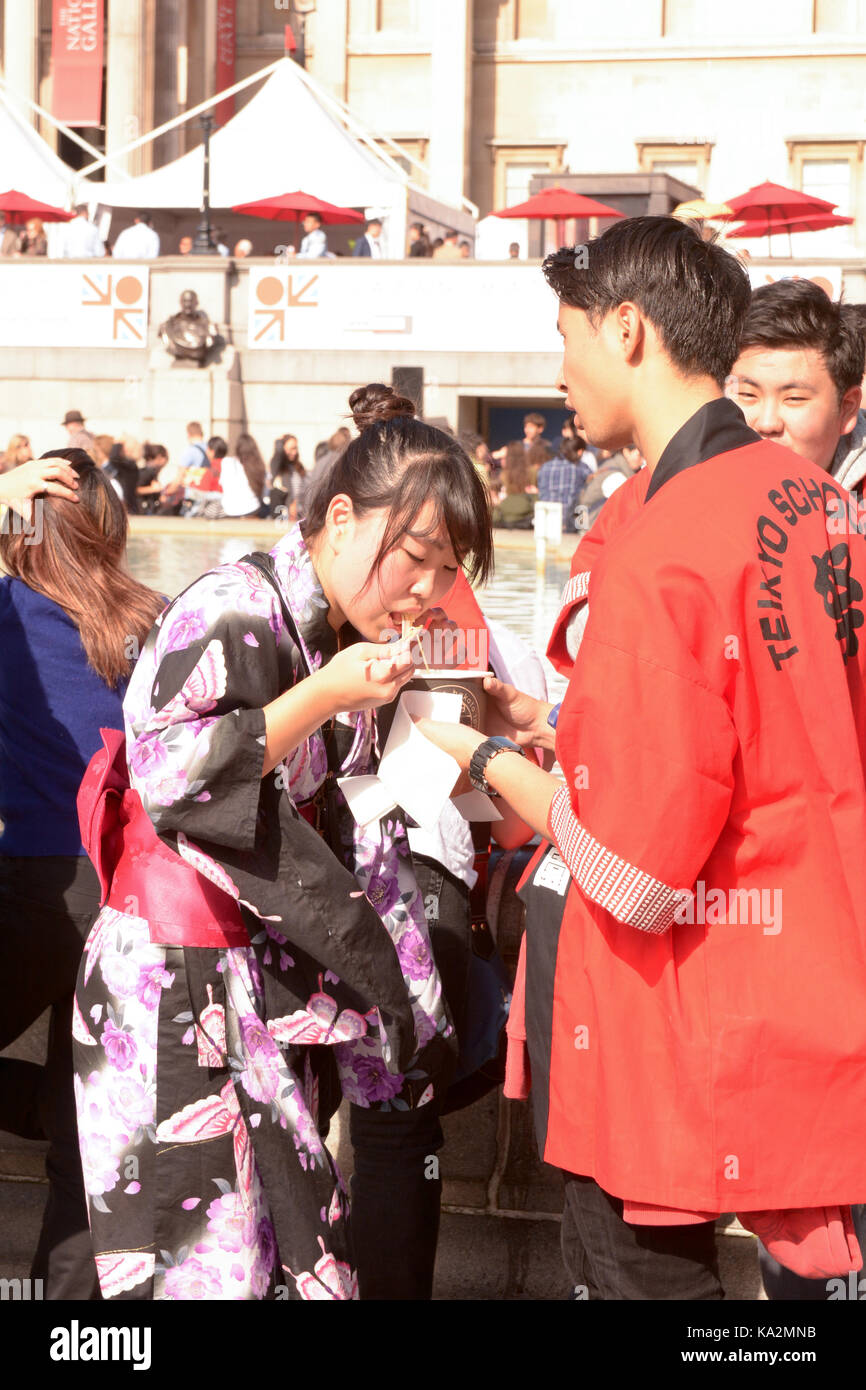 London, England. 24 September 2017: Man and Woman in traditional Japanese clothing eating noodles at the Japan Matsuri Festival in Trafalgar Square, London England. Martin Parker/Alamy Live News Stock Photo