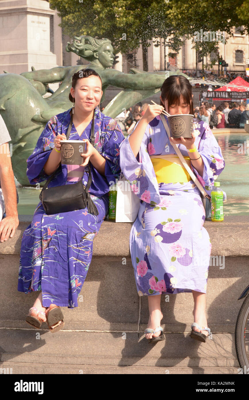 London, England. 24 September 2017: Two women in traditional Japanese kimono dresses eating noodles at the Japan Matsuri Festival in Trafalgar Square, London England. Martin Parker/Alamy Live News Stock Photo