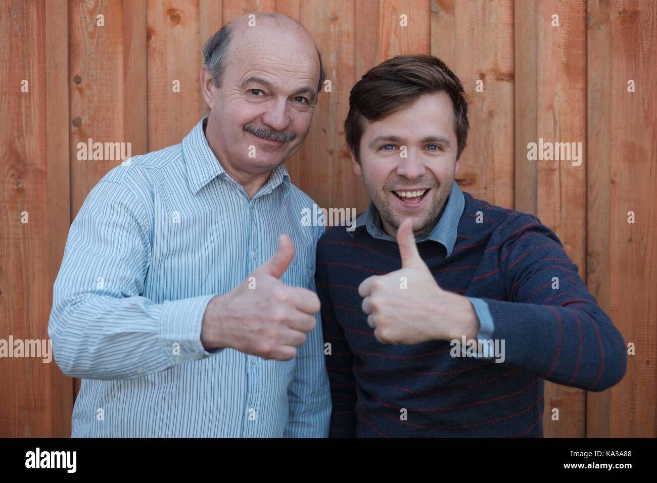 Two happy men giving thumbs up sign. Stock Photo