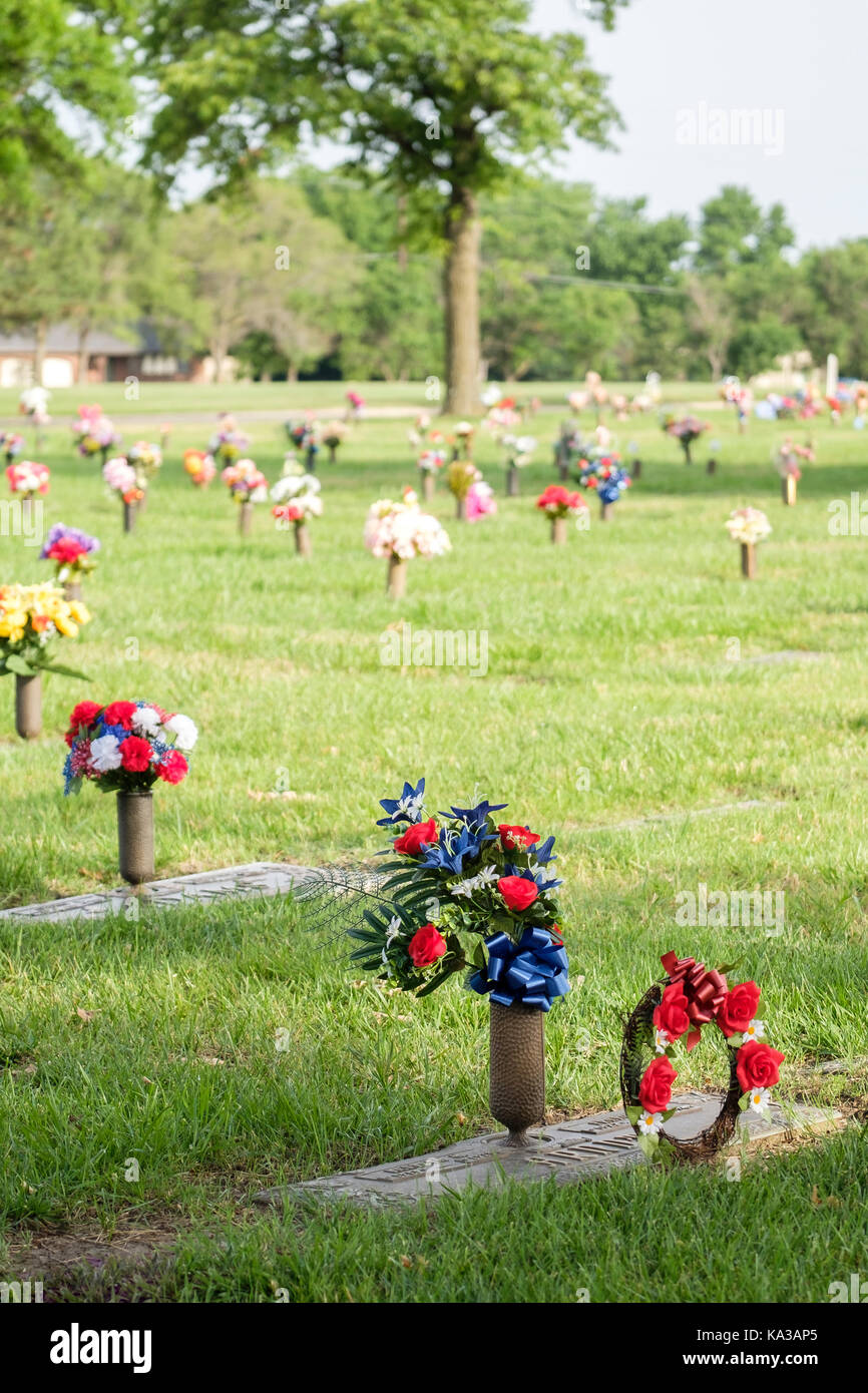 Gravesite floral decorations honoring the dead on Memorial Day in a cemetary in Wichita, Kansas, USA. Stock Photo