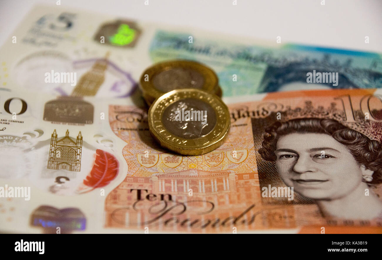 Polymer currency note and twelve sided pound sterling coin in full frame view Stock Photo