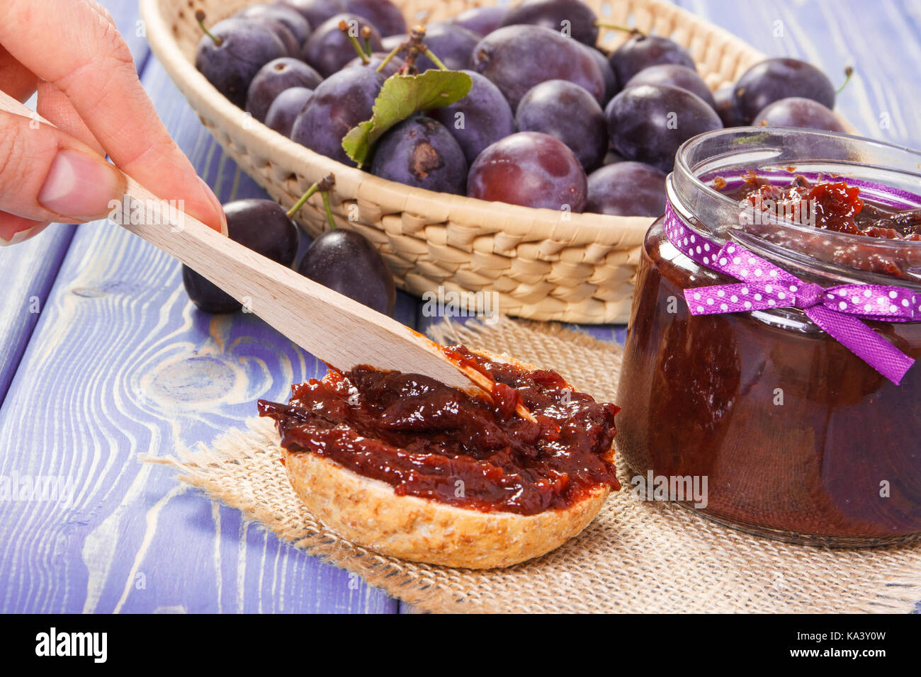 Preparing sandwiches with homemade plum marmalade or jam, concept of healthy sweet snack, breakfast or dessert Stock Photo