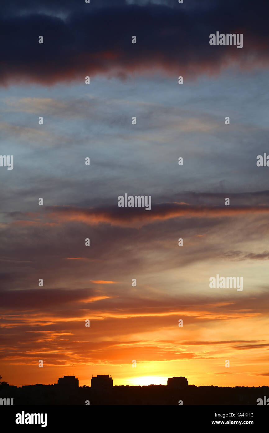 Photo of a brightly beautiful sunset with clouds over the city of ...