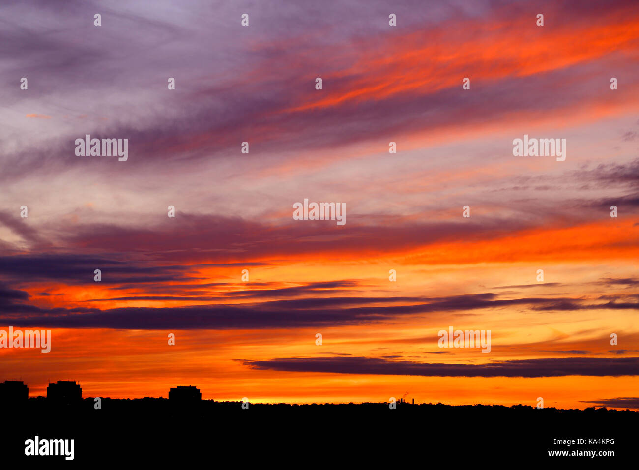 Photo of a brightly beautiful sunset with clouds over the city of ...