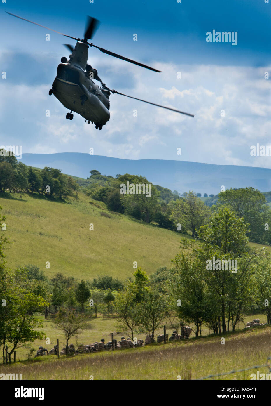A CH47 Chinook helicopter of the RAF over flies British Army soldiers on the Sennybridge military training area in Wales Stock Photo