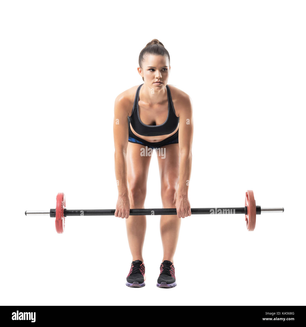 Front view of bent female athlete doing dead lift exercise with barbell looking away. Full body length portrait isolated on white studio background. Stock Photo