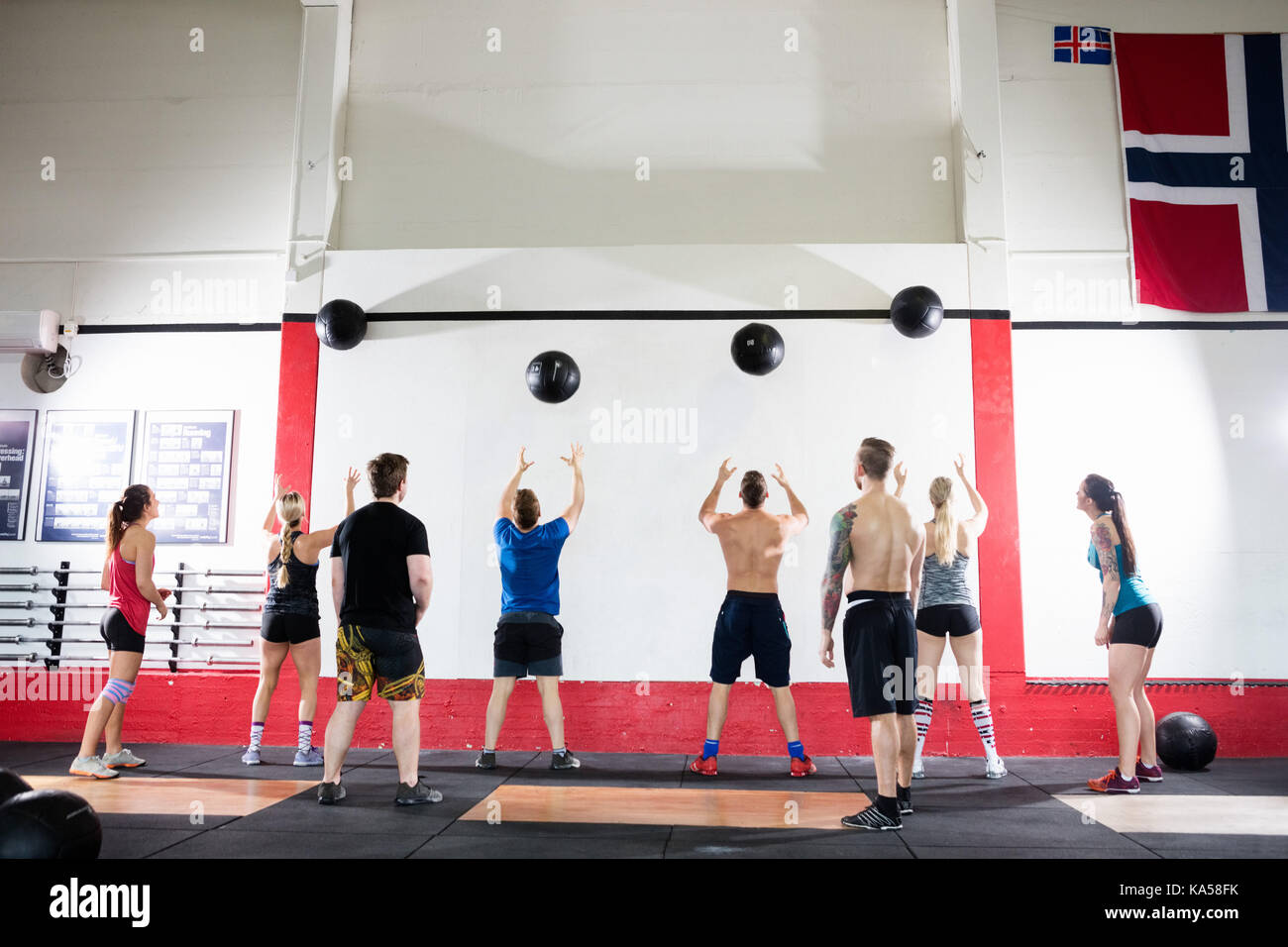 Clients Throwing Medicine Balls On Wall In Gym Stock Photo Alamy