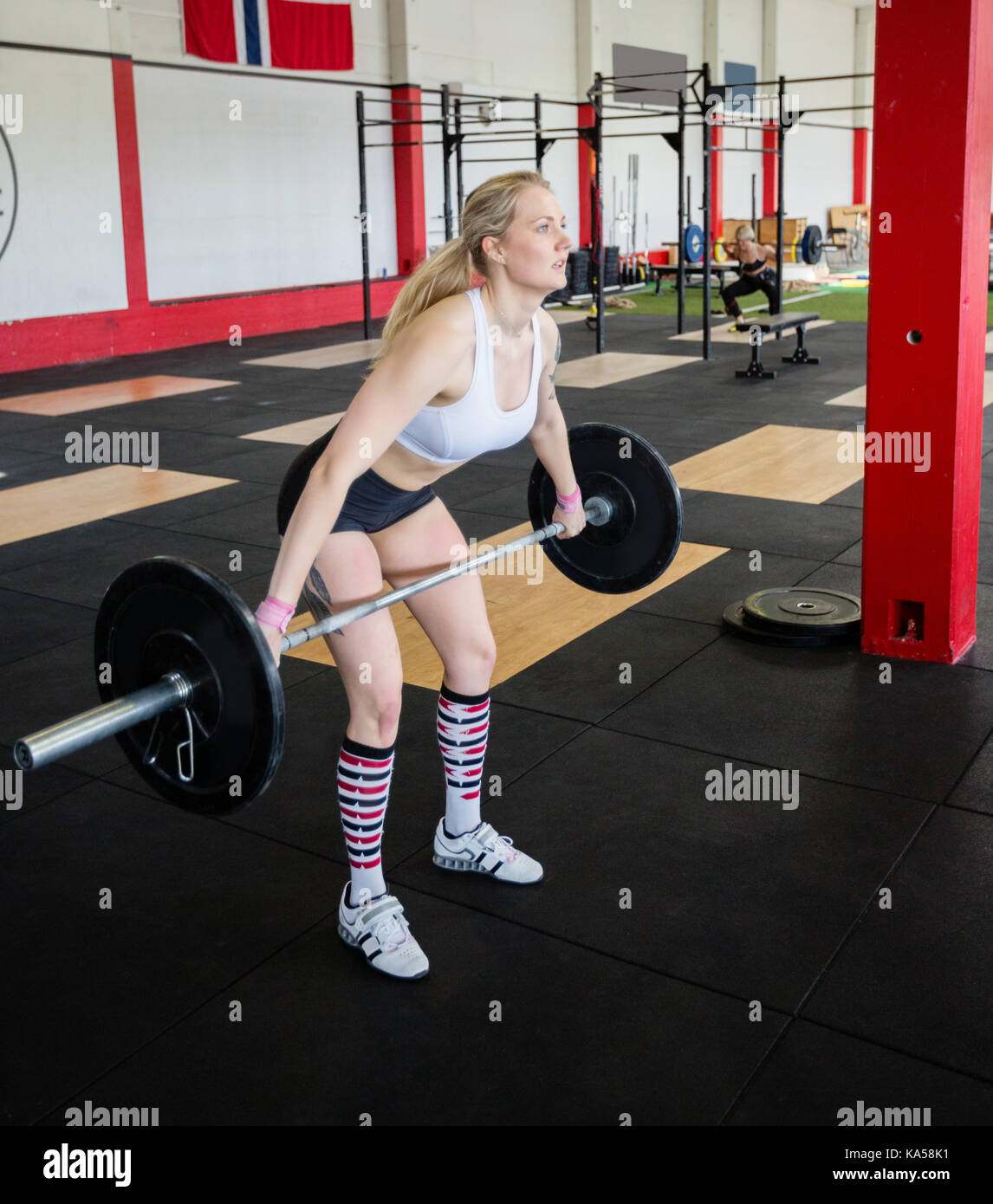 Woman In Sportswear Lifting Barbell In Fitness Center Stock Photo