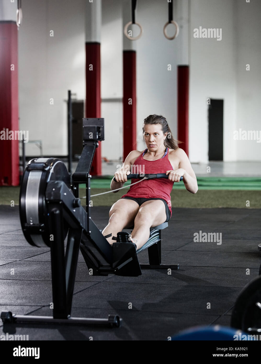Fit Woman Exercising On Rowing Machine Stock Photo