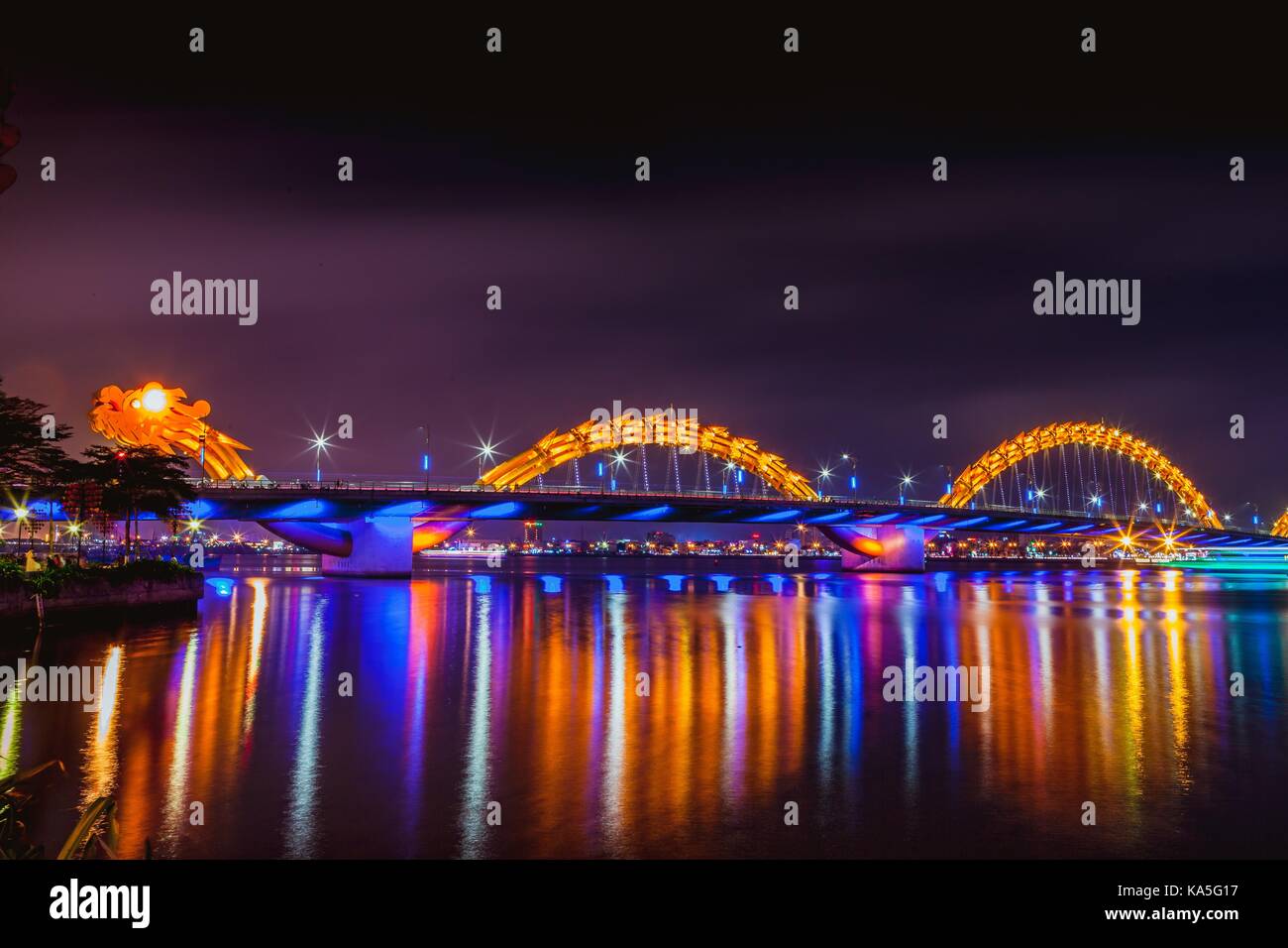 DA NANG, VIETNAM - MARCH 19, 2017: Dragon Bridge at night in Da Nang, Vietnam. Beautiful photo of modern city in night illumination. Stock Photo