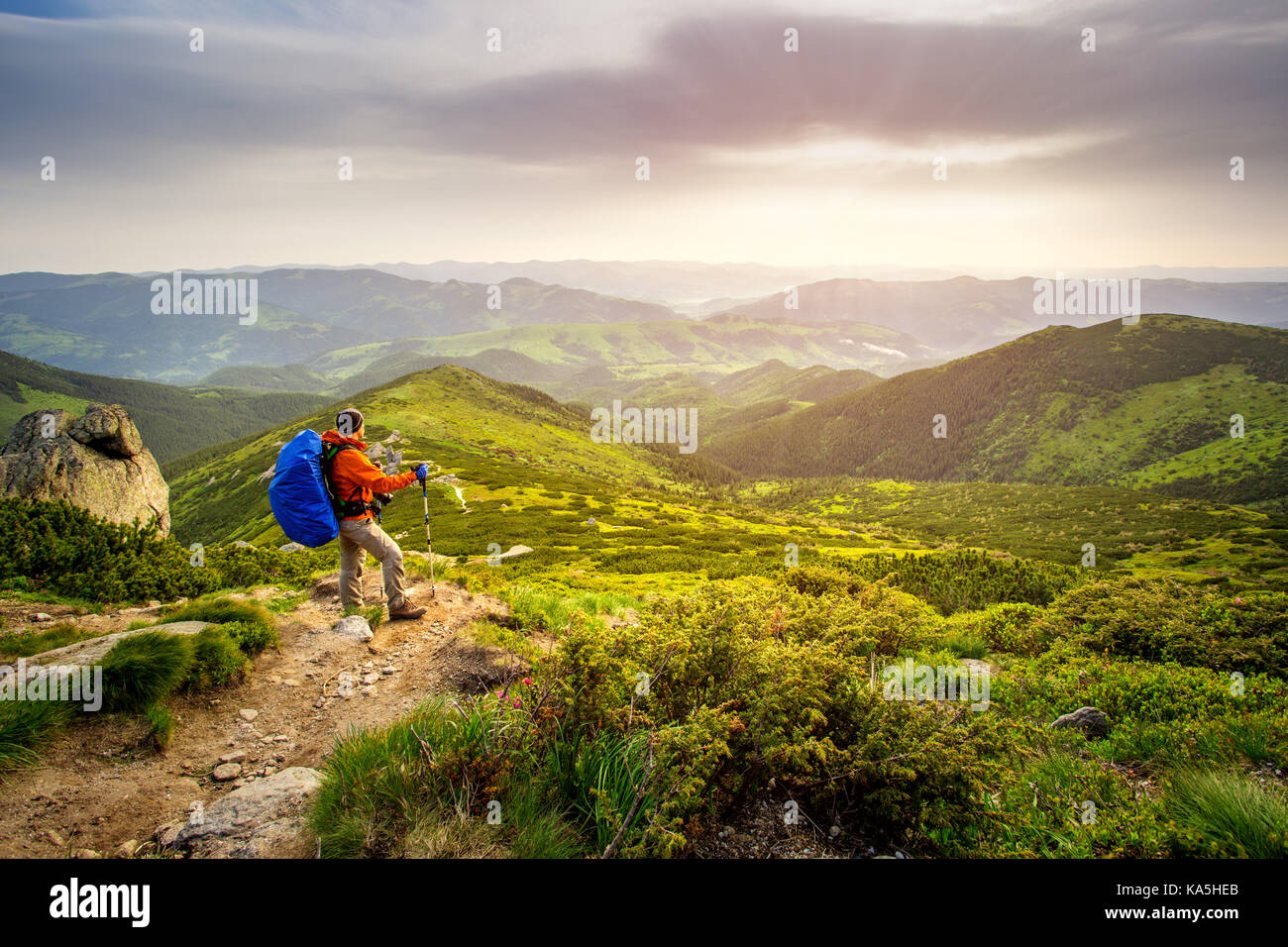 Traveler Man hiking with backpack admiring a beautiful landscape. HDR foto. Stock Photo