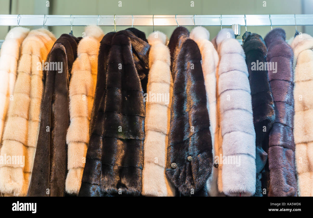 Collection of fur coats in shop, store showcase, rich winter wardrobe Stock Photo