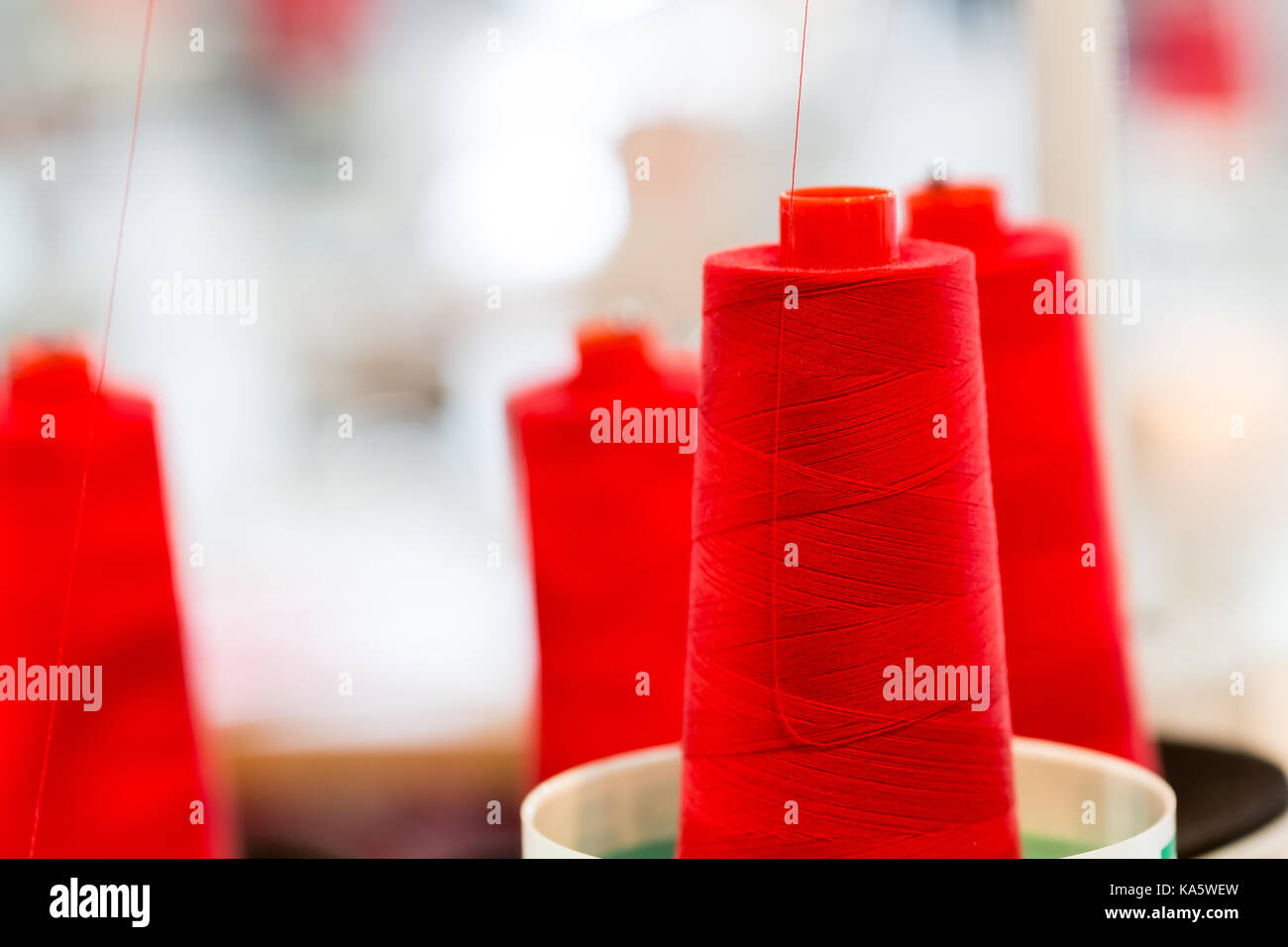 Spools of red threads closeup, sewing material. Textile manufacturing