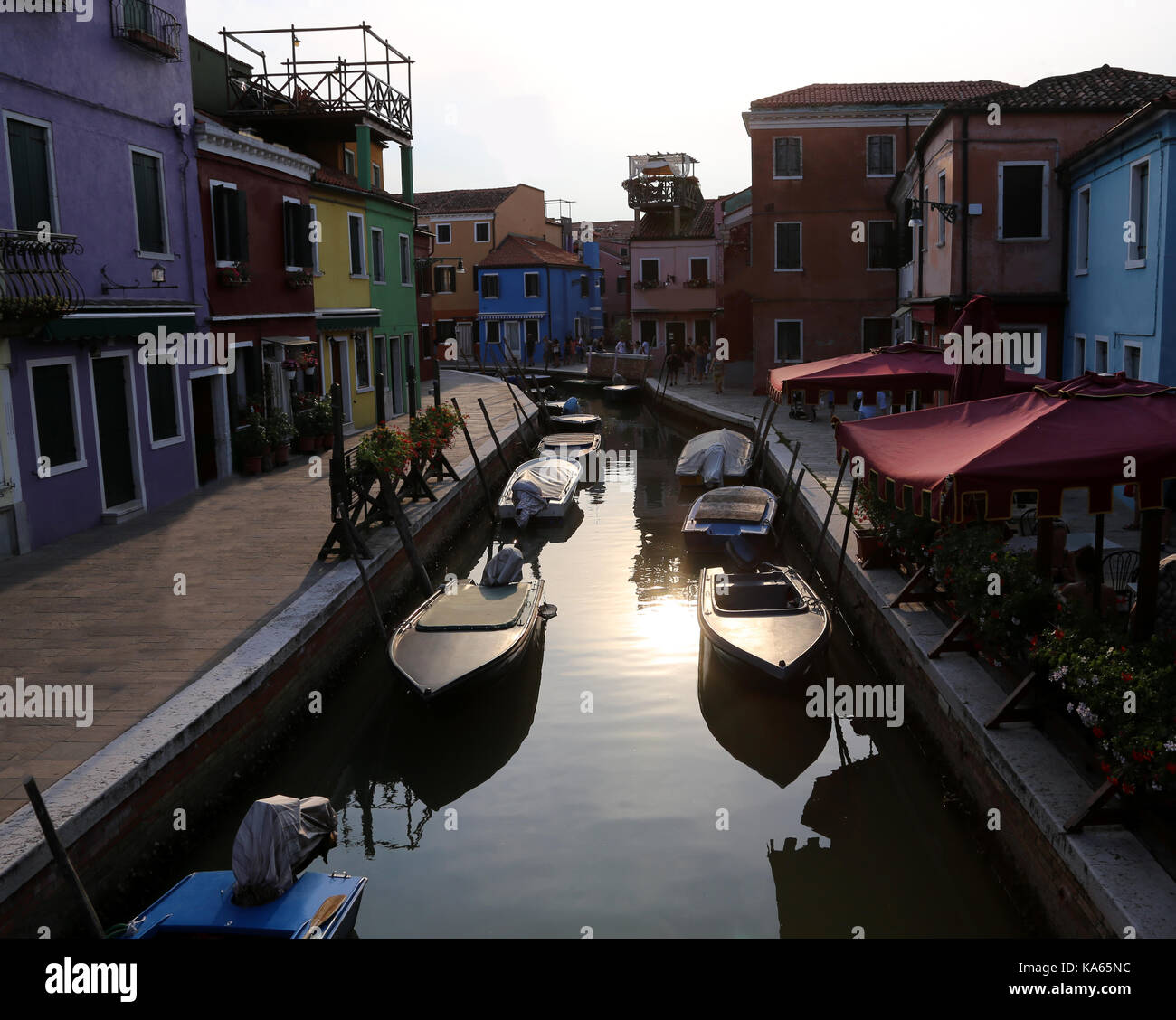 Boats moored in the navigable canal of Burano island near Venice in Northern Italy Stock Photo