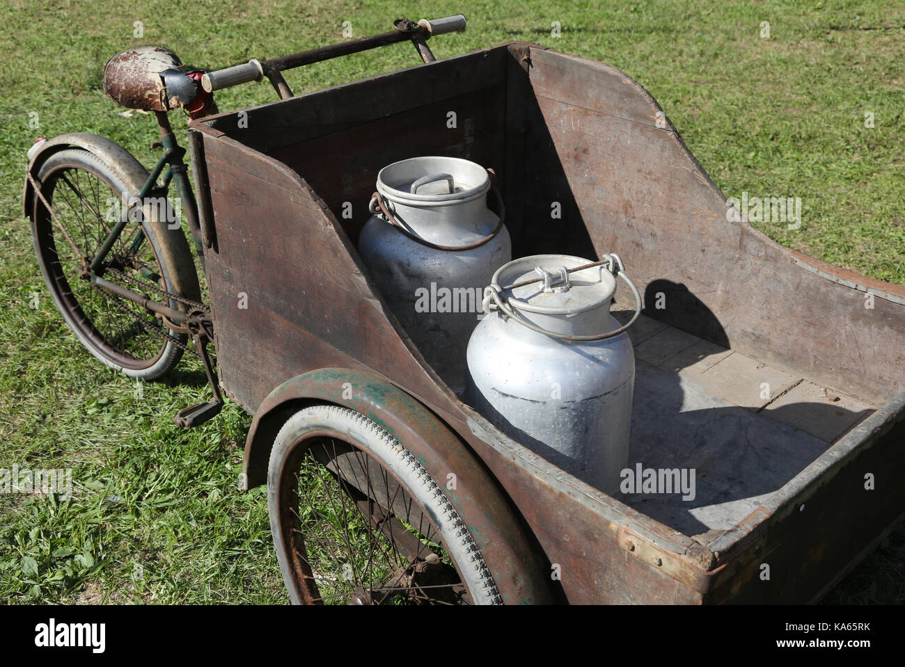 ancient wooden cart with old bicycle to transport the milk just leavened from the farm to the dairy Stock Photo