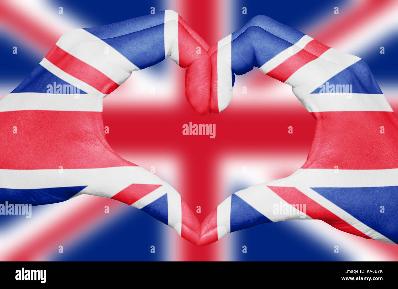 United kingdom flag painted on hands forming a heart isolated on blurred Union Jack background, UK national and patriotism concept Stock Photo